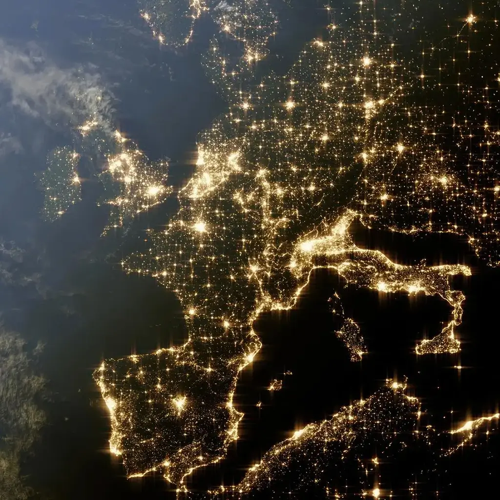 Vista satellitare notturna dell'Europa occidentale e del Mediterraneo, con le luci delle città che illuminano il continente e tracciano i confini geografici.